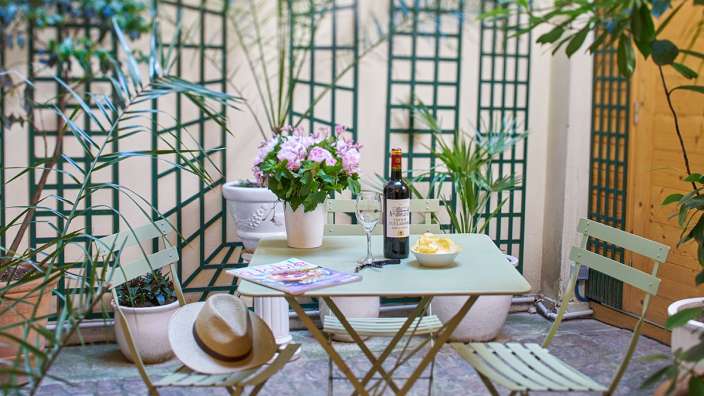 Ein Tisch mit zwei Stühlen und einer Flasche Wein