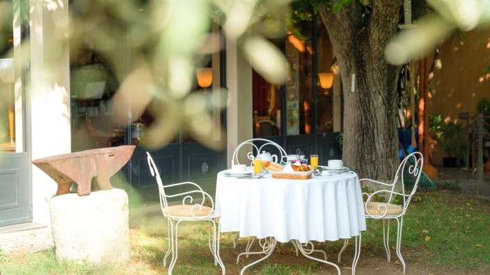 Ein Tisch mit einem weißen Tischtuch und Stühlen darauf