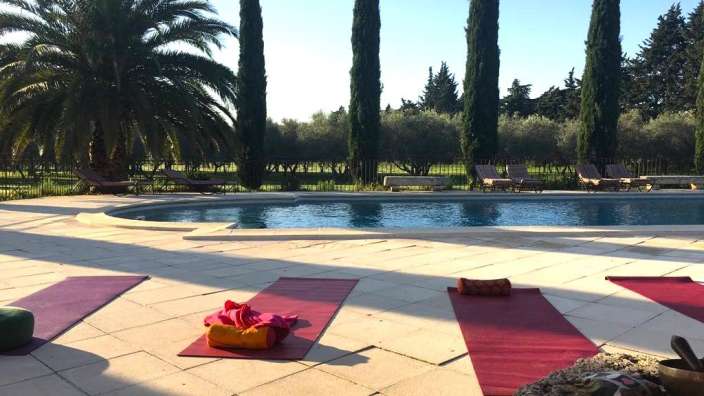 Eine Gruppe von Yogamatten liegt neben einem Pool