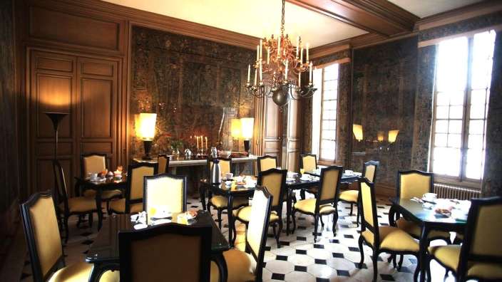 Ein Esszimmer mit Tisch und Stühlen und einem Kronleuchter