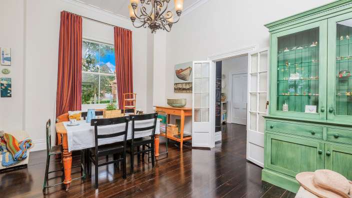 Ein Esszimmer mit einem Tisch und Stühlen und einem grünen Schrank
