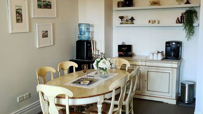 Ein Esszimmer mit einem Tisch und Stühlen und einem Wasserspender