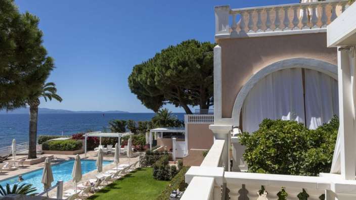 Ein Balkon mit Blick auf einen Pool und das Meer