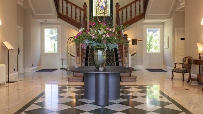 Ein Flur mit einem Tisch und einer Vase mit Blumen darauf