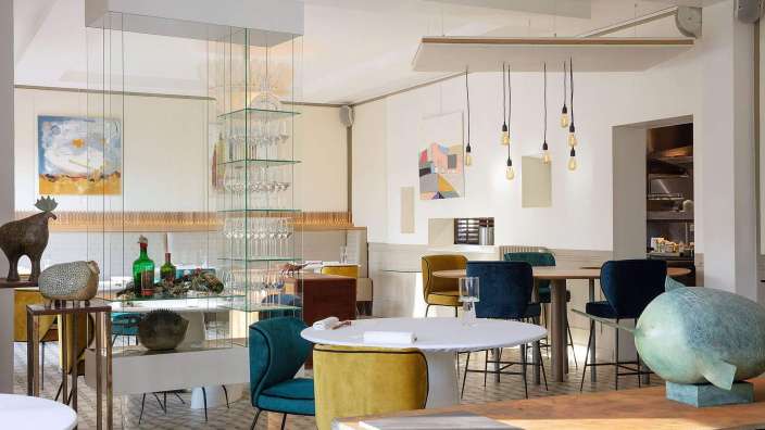 Ein Esszimmer mit vielen Tischen und Stühlen