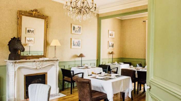 Ein Esszimmer mit Tischen und Stühlen und einem Kamin