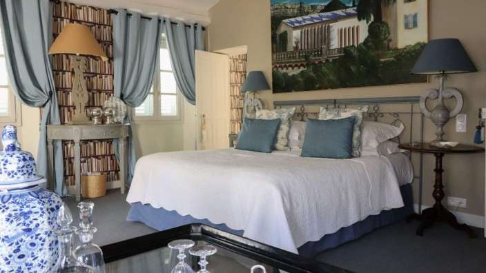 Ein Schlafzimmer mit einem Bett und einem Gemälde an der Wand