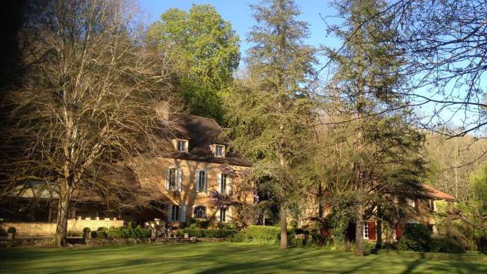 Ein großes Haus mit vielen Bäumen davor