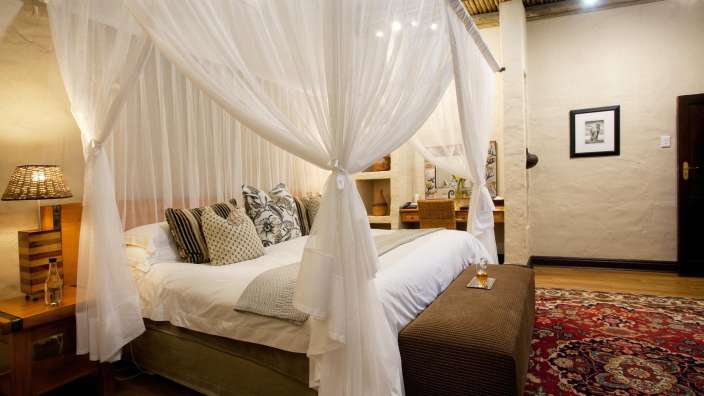 Ein Himmelbett mit weißen Vorhängen in einem Schlafzimmer