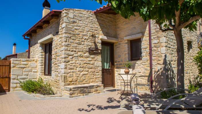 Ein kleines Steinhaus mit einem Schild an der Wand , das sagt " zimmer "