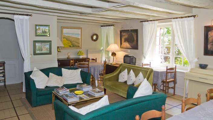 Ein Wohnzimmer mit grünen Möbeln und einem Fernseher