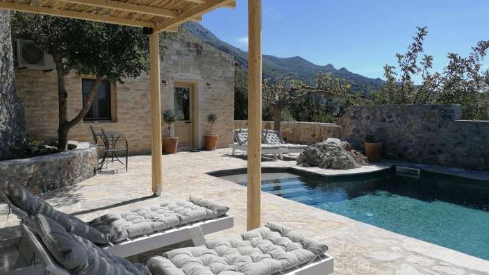 Liegestühle auf einer Terrasse neben einem Swimmingpool