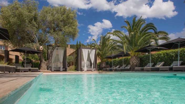 Ein großer Pool mit Liegestühlen und Sonnenschirmen umgeben