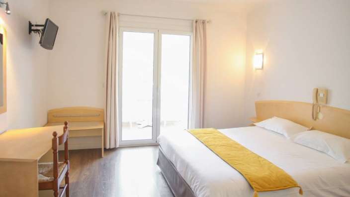 Ein Hotelzimmer mit einem Bett und einem Fernseher