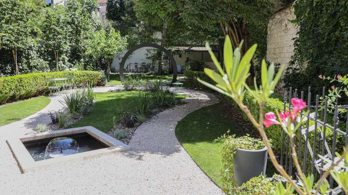 Ein Garten mit einem Brunnen und einem Weg