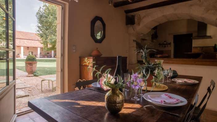 Ein holztisch mit tellern und gläsern und einer vase mit blumen darauf