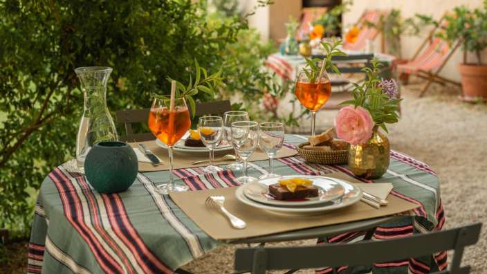 Ein Tisch mit gedeckten Tellern und Gläsern auf einem gestreiften Tischtuch