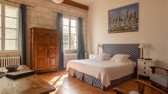 Ein Schlafzimmer mit einem großen Bett und einem Gemälde an der Wand