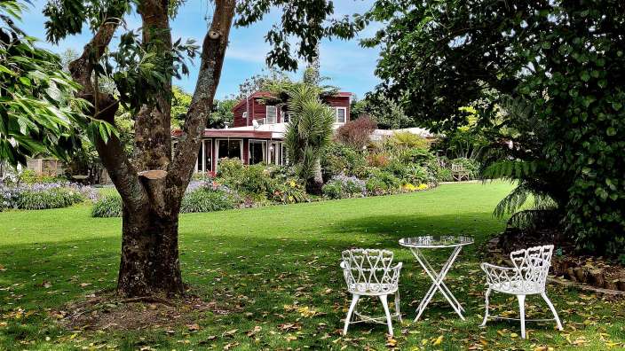 Ein Tisch und Stühle stehen auf einem grünen Rasen vor einem Haus