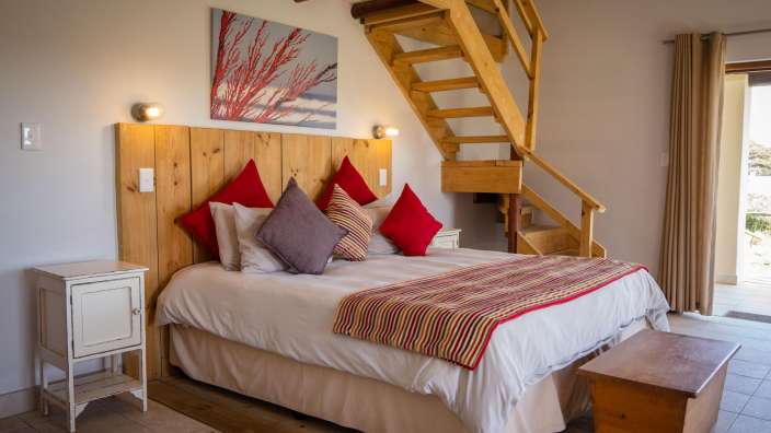 Ein Schlafzimmer mit einem Bett und einer Holztreppe