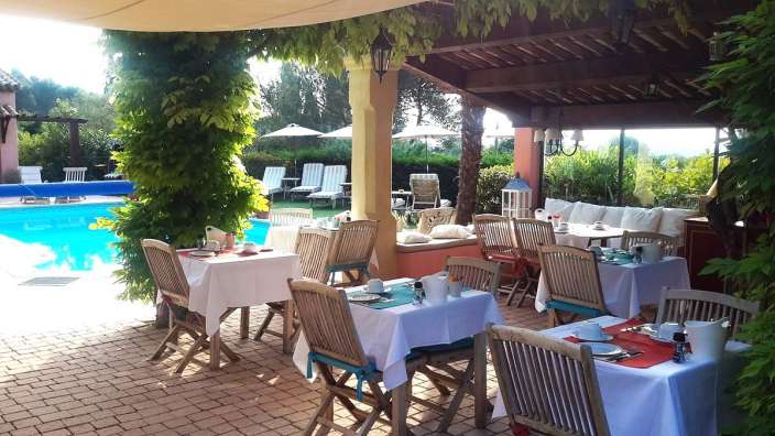 Eine Terrasse mit Tischen und Stühlen neben einem Swimmingpool
