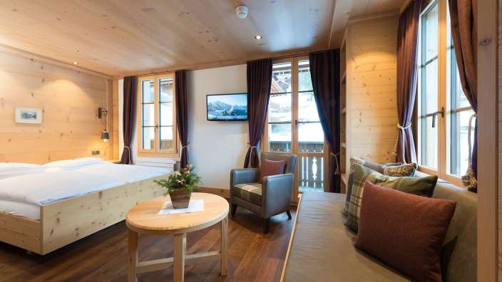 Ein Schlafzimmer mit einem Bett, einem Stuhl, einem Tisch und einem Fernseher