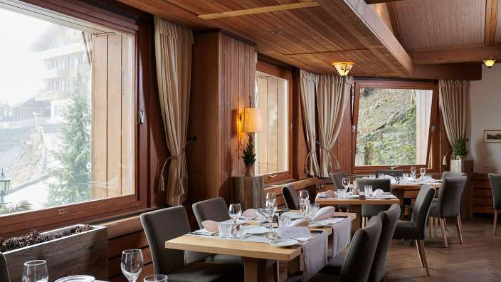Tische und Stühle in einem Restaurant mit vielen Fenstern