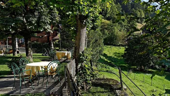 Ein Tisch mit einer weißen Tischdecke und grünen Stühlen