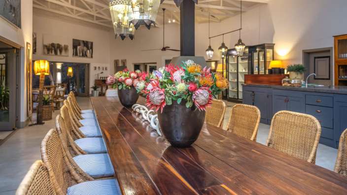 Ein langer Holztisch mit zwei Vasen mit Blumen darauf