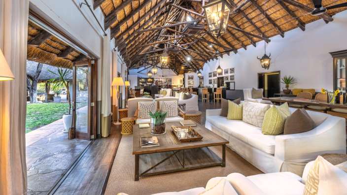 Ein Wohnzimmer mit weißen Möbeln und einem Strohdach