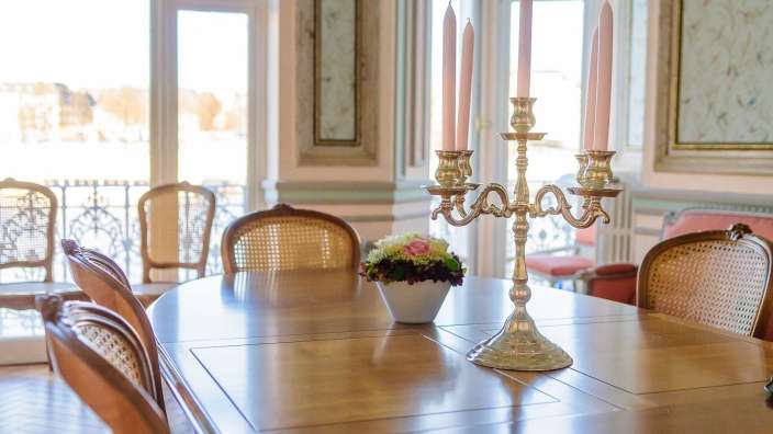 Ein Tisch mit einem Kerzenhalter und einer Vase mit Blumen darauf