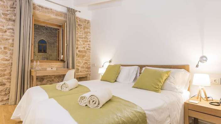 Ein Schlafzimmer mit weißen Betten und grünen Kissen