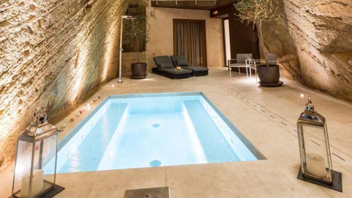 Ein kleiner Pool in einem Raum mit Laternen und Stühlen