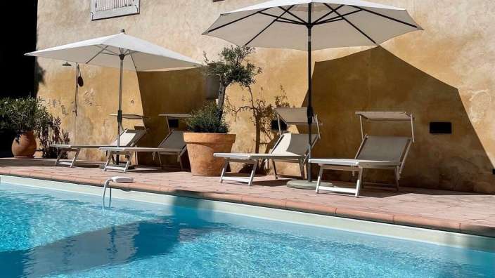 Liegestühle und Sonnenschirme um einen Swimmingpool