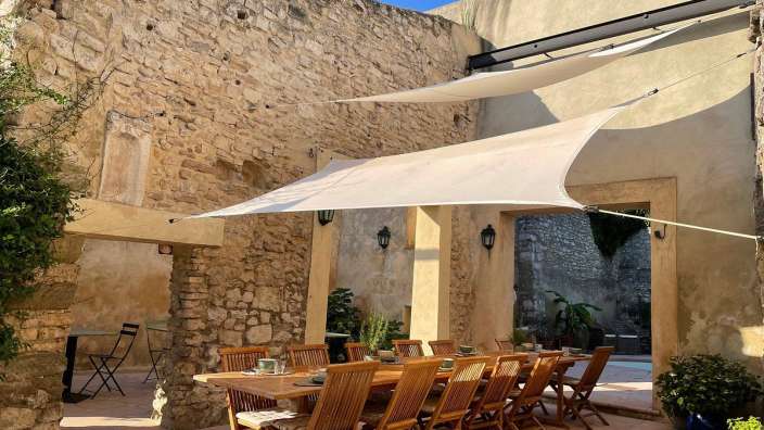 Ein Tisch und Stühle unter einem weißen Sonnenschirm