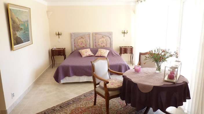 Ein Schlafzimmer mit einem lila Bett und einem Tisch