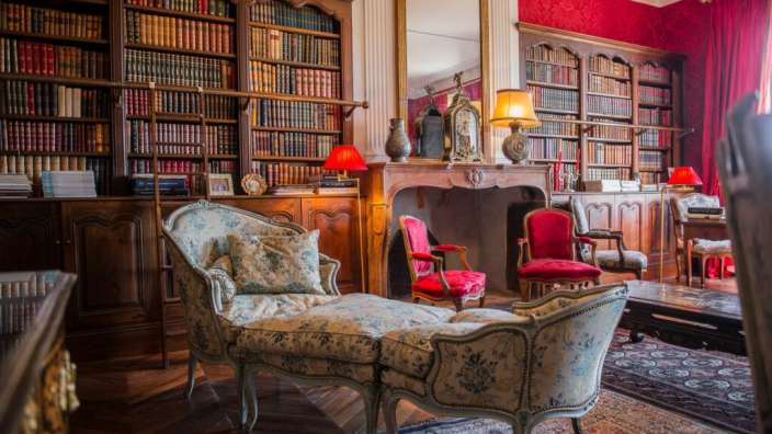 Ein Wohnzimmer mit vielen Büchern und einem Kamin