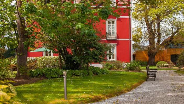 Ein rotes Haus mit einer Bank davor