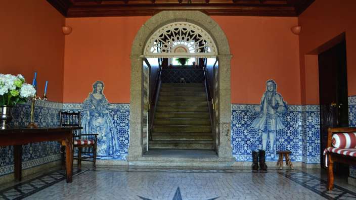 Ein Flur mit blau-weißen Fliesen und einer Treppe