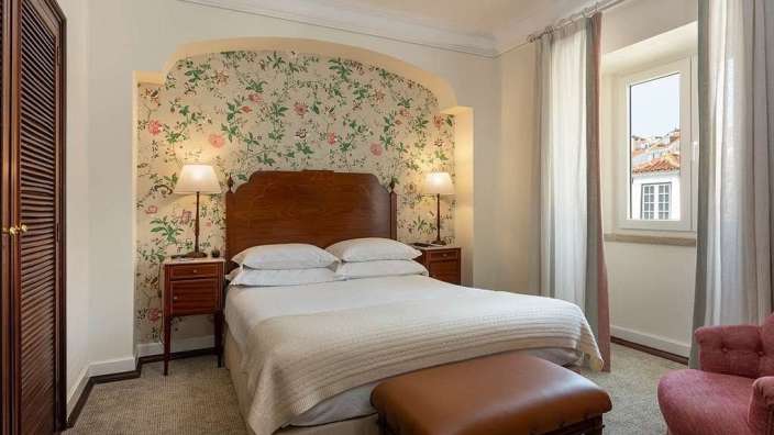 Ein kleines Schlafzimmer mit einem Bett und einem Stuhl