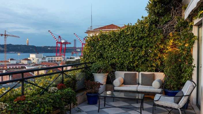 Ein Balkon mit einer Couch und Stühlen und einem Tisch