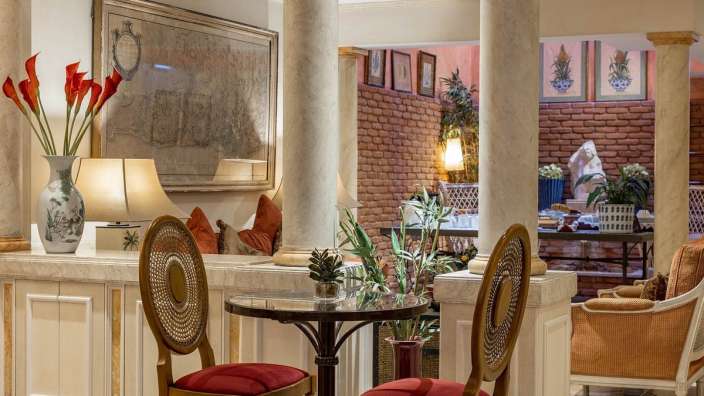 Ein Wohnzimmer mit einem Tisch und Stühlen und einem Gemälde an der Wand