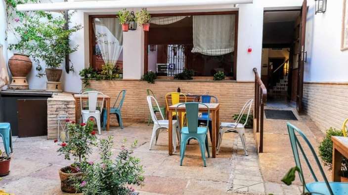Eine Terrasse mit bunten Tischen und Stühlen vor einem Gebäude