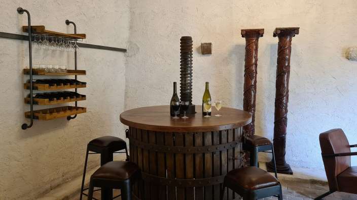 Ein Weinkeller mit einem Holztisch und Stühlen