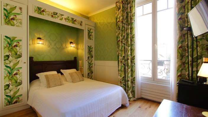 Ein Schlafzimmer mit einem Bett und grünen Vorhängen