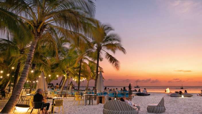 Eine Gruppe von Menschen sitzt an einem Tisch am Strand