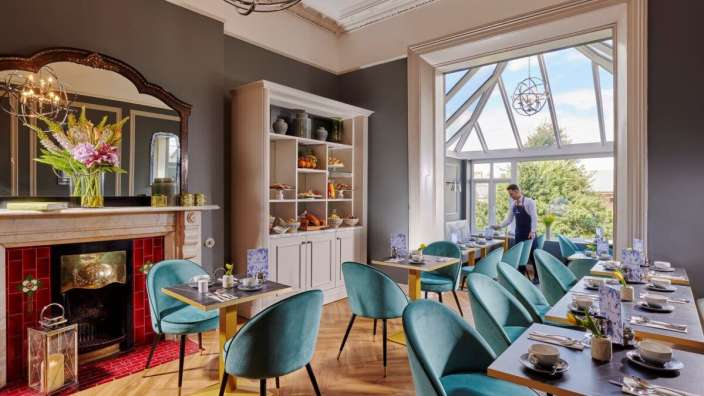 Ein Mann steht in einem Esszimmer mit vielen Tischen und Stühlen