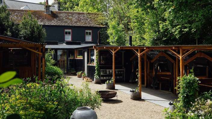 Ein Garten mit einem schwarzen Haus im Hintergrund