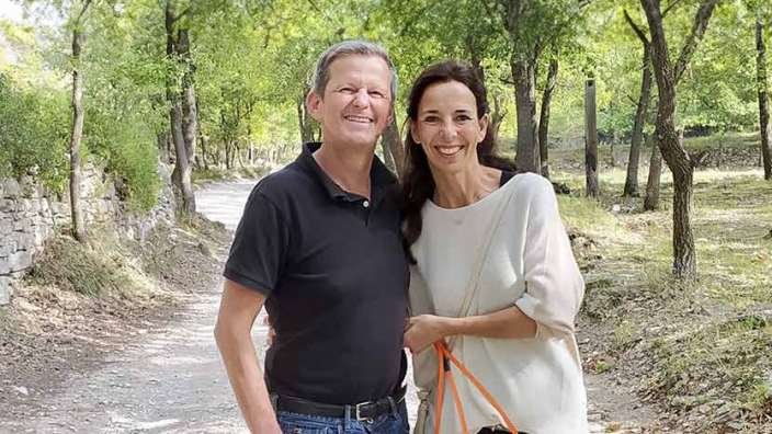 Ein Mann und eine Frau stehen auf einem Feldweg und lächeln