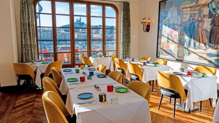 Tische und Stühle in einem Restaurant mit einem Gemälde an der Wand
